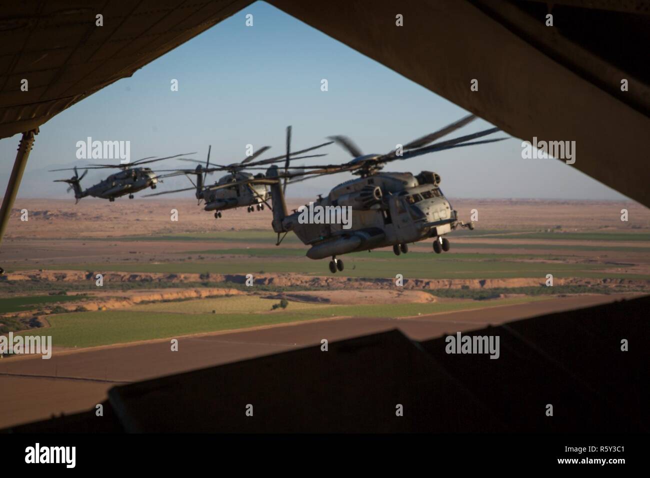 CH-53E Super Stallions assigned to Marine Heavy Helicopter Squadron (HMH) 466 fly in formation while transporting Marines during an exercise in part of Weapons and Tactics Instructors course (WTI) 2-17 near Yuma, Ariz., April 20, 2017. WTI is held biannually at Marine Corps Air Station (MCAS) Yuma, Ariz., to provide students with detailed training on the various ranges in Arizona and California. Stock Photo