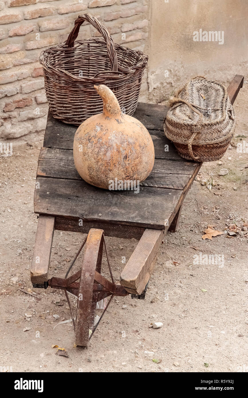 outdoor scene of an antique wooden wheelbarrow with iron wheel carrying
