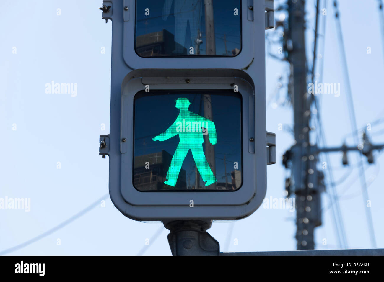 A green traffic light sign that says people can walk or pedestrian walking. This traffic sign was taken in Japan. Stock Photo