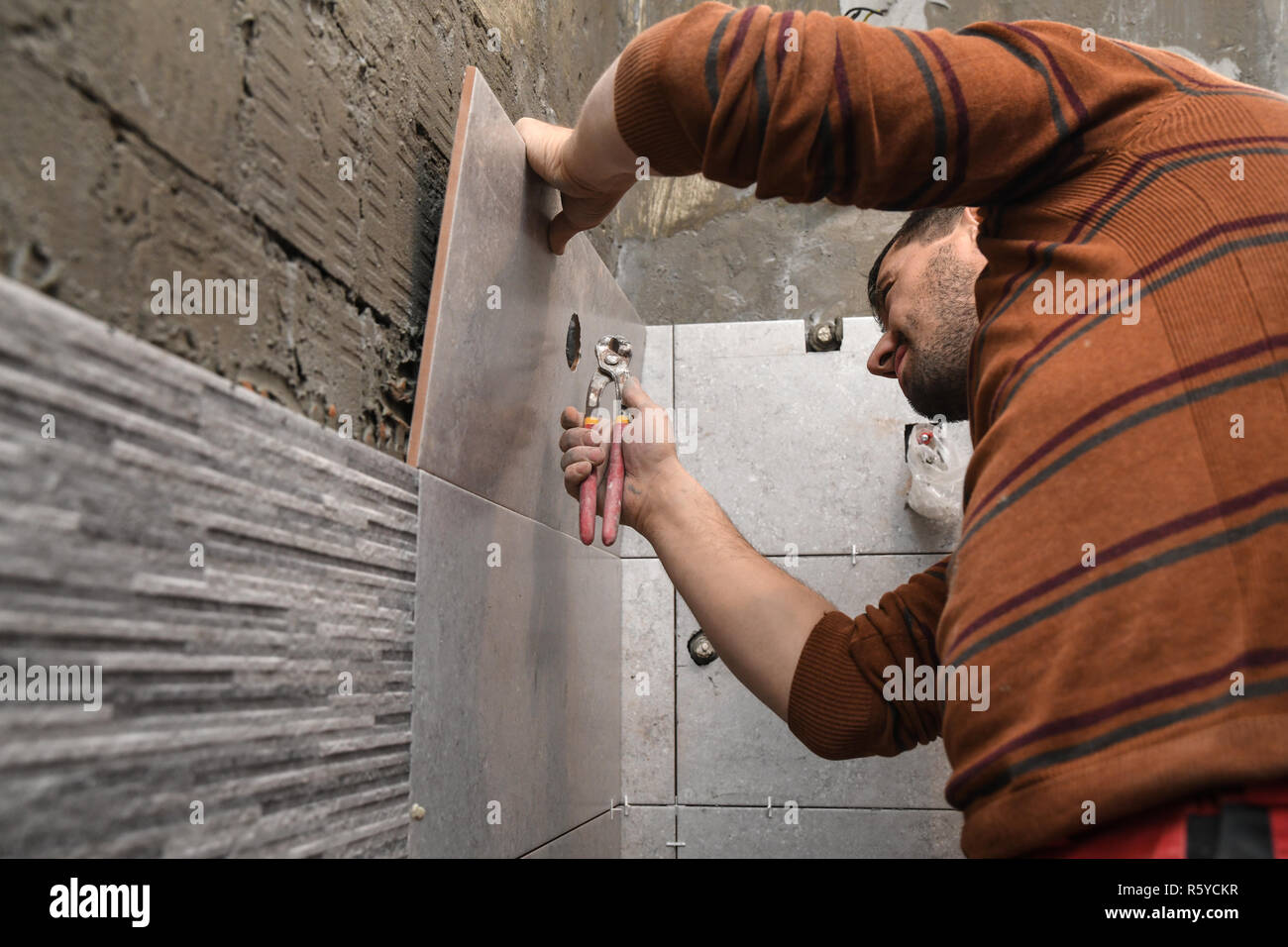 Cutting ceramic tiles manualy. Opening a hole in the tile Stock Photo