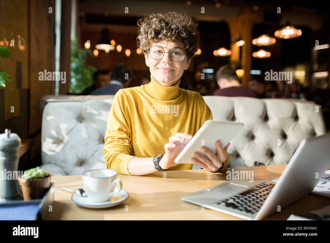 Attractive hipster lady working with tablet in restaurant Stock Photo