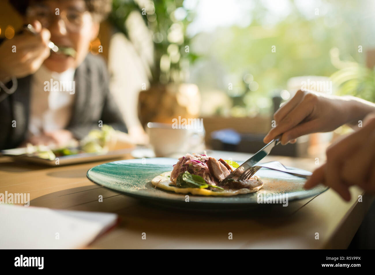 Cutting meat slice while eating delicious dish Stock Photo