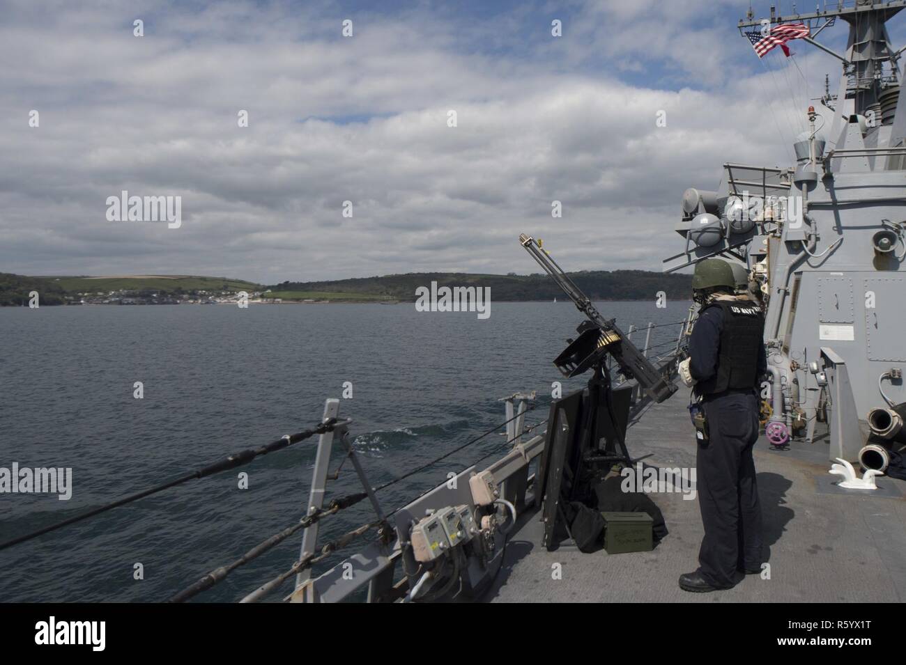 PLYMOUTH, United Kingdom (April 21, 2017) - Sailors aboard USS Carney (DDG 64) man an M2 .50 cal. machine gun as part of the small craft action team as the ship arrives in Plymouth, United Kingdom as it participates in Flag Officer Sea Training April 21, 2017. Carney, an Arleigh Burke-class guided-missile destroyer, forward-deployed to Rota, Spain, is conducting its third patrol in the U.S. 6th Fleet area of operations in support of U.S. national security interests in Europe. Stock Photo