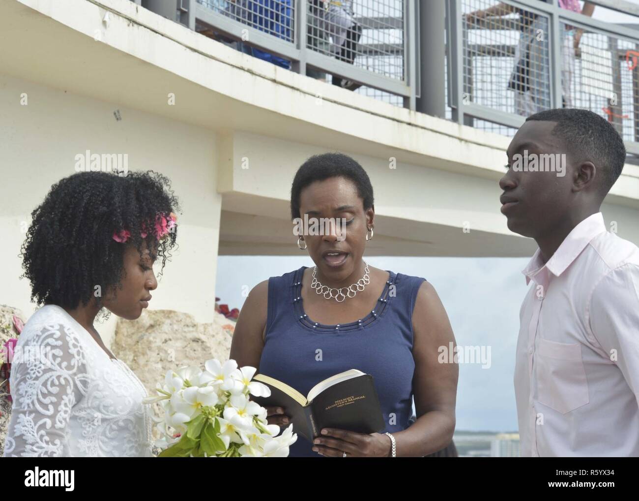 TAMUNING, Guam (April 23, 2017) Lt. Takana Jefferson, a Protestant/gospel chaplain stationed on submarine tender USS Emory S. Land (AS 39), officiates a wedding ceremony for Electronics Technician 2nd Class Kiontre Daniels, also assigned to Land, and Ti'roynei Jones at Two Lovers Point in Tamuning Guam April 23. Apra Harbor, Guam, is homeport to four forward-deployed submarines and both of the U.S. Navy's submarine tenders, which are maintained as part of the Navy's forward-deployed submarine force and arereadily capable of meeting global operational requirements Stock Photo