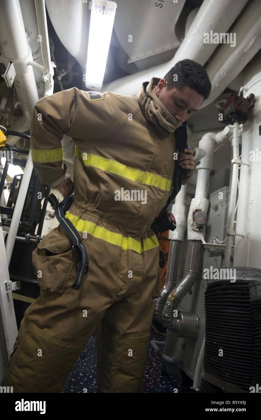 MEDITERRANEAN SEA (April 24, 2017) Logistics Specialist 3rd Class Tomas Castano, from Long Branch, New Jersey, dons fire fighting equipment aboard USS Ross (DDG 71) during a damage control training exercise April 24, 2017. Ross, an Arleigh Burke-class guided-missile destroyer, forward-deployed to Rota, Spain, is conducting naval operations in the U.S. 6th Fleet area of operations in support of U.S. national security interests in Europe and Africa. Stock Photo