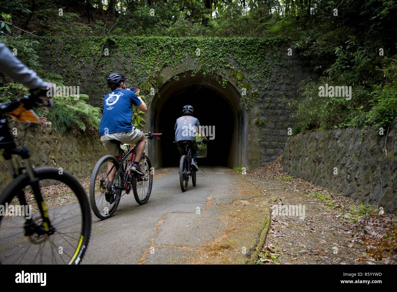 Participants in the Tour de Tama mountain bike race ride through a tunnel April 22, 2017, at Tama Hills Recreation Area, Japan. The course was approximately three miles in length and an approximate 3000 feet in combined elevation gain. Stock Photo
