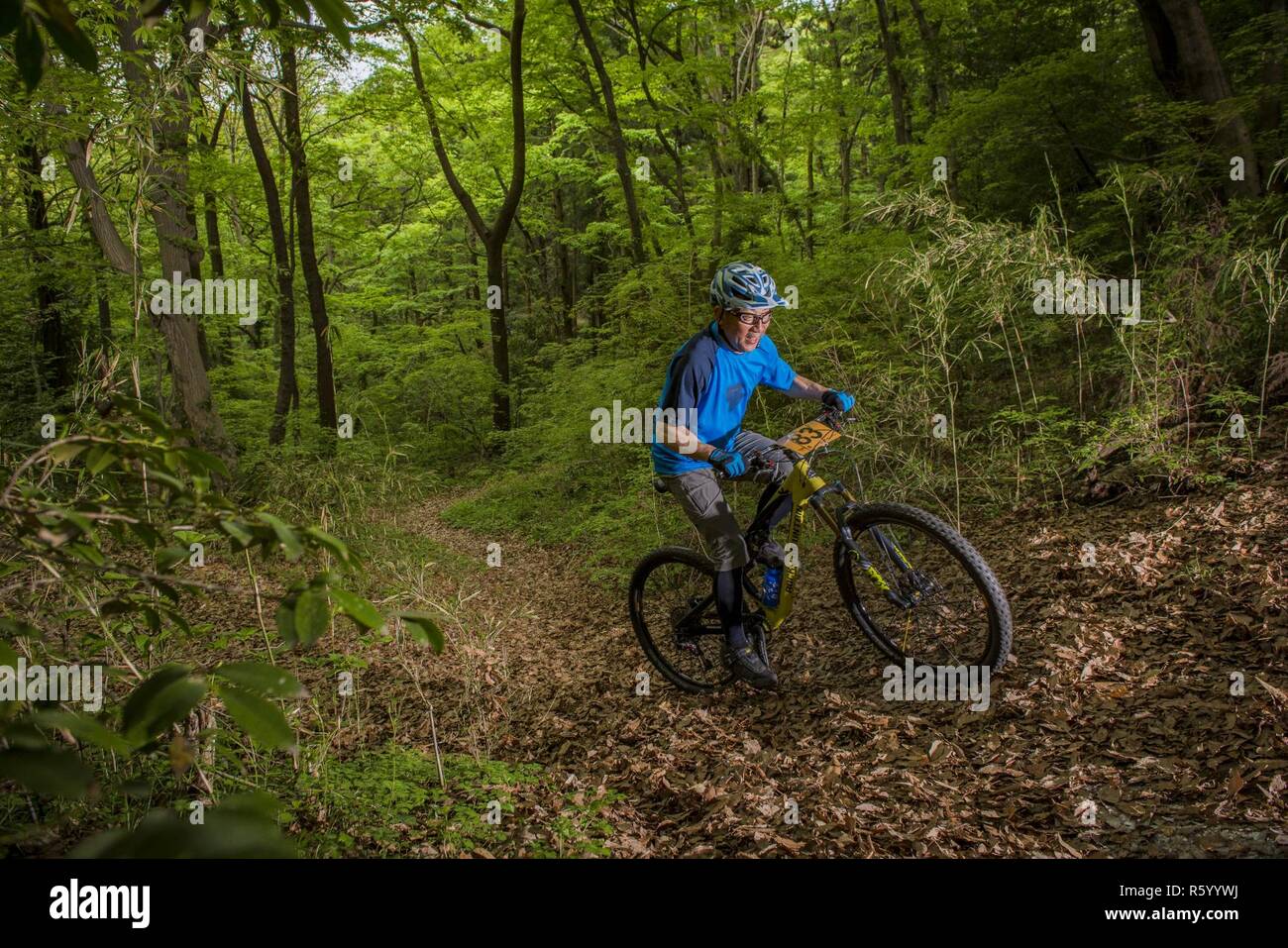 A participant in the Tour de Tama mountain bike race peddles uphill April 22, 2017, at Tama Hills Recreation Area, Japan. The course was approximately three miles in length and an approximate 3000 feet in combined elevation gain. Stock Photo