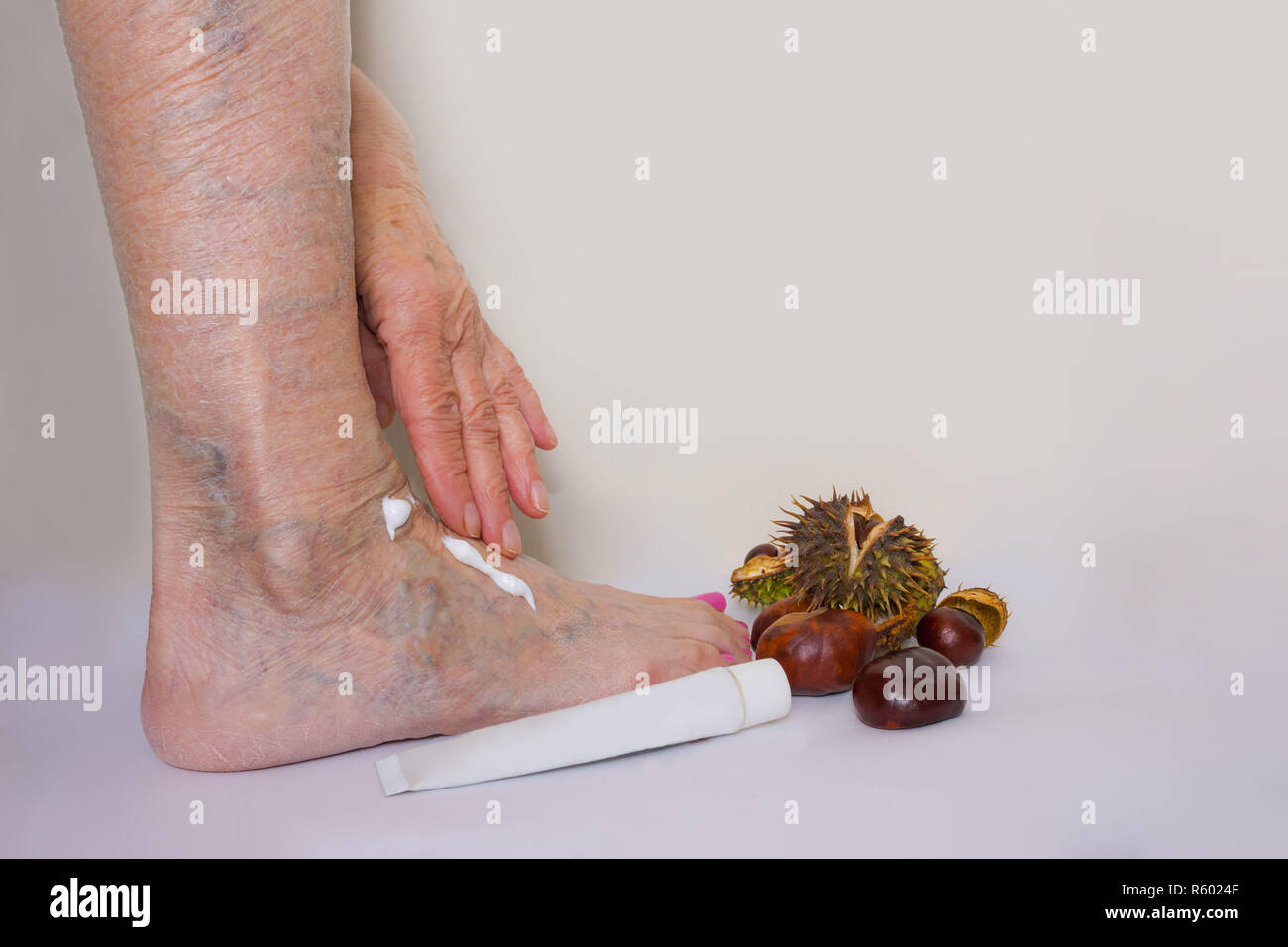 The female leg and hand with medicine cream from horse chestnuts Stock Photo