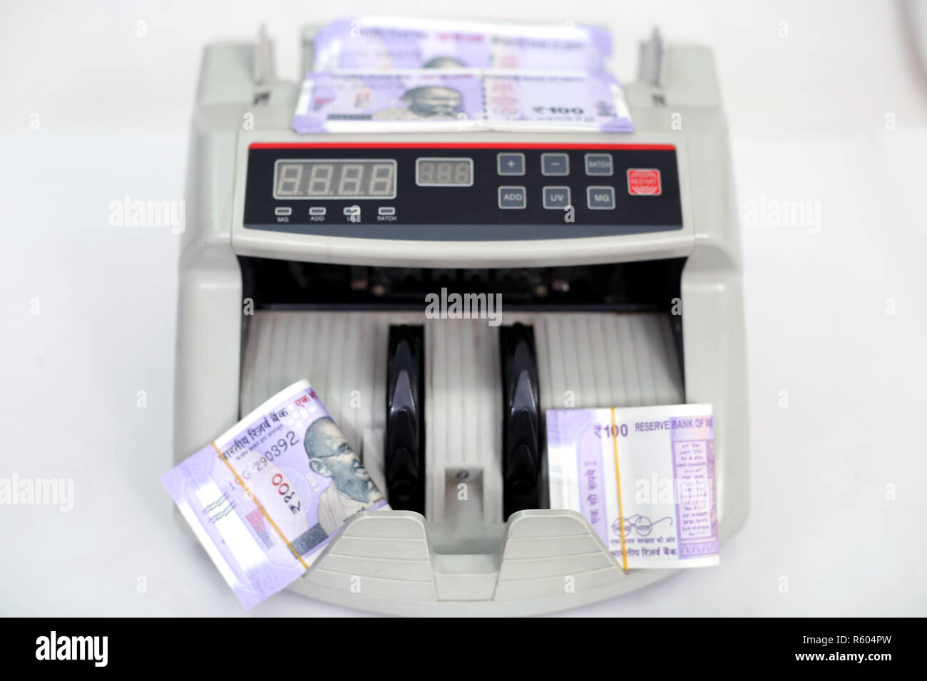 Money counting machine with new 100 rupees notes. Isolated on the white