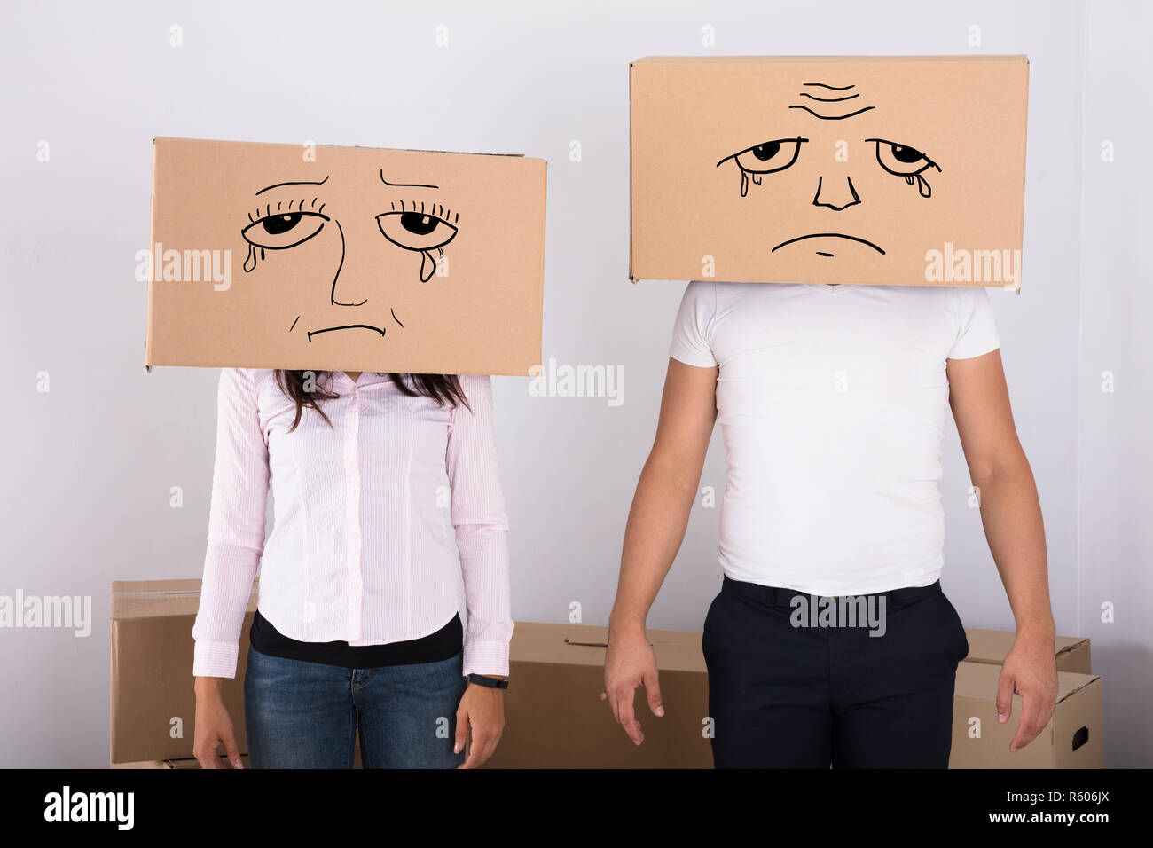 Sad Couple Wearing Cardboard Boxes Stock Photo