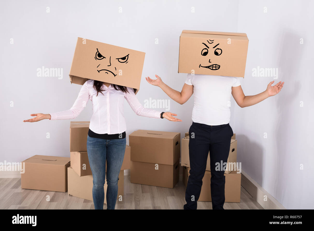 Couple Wearing Cardboard Boxes Shrugging Stock Photo
