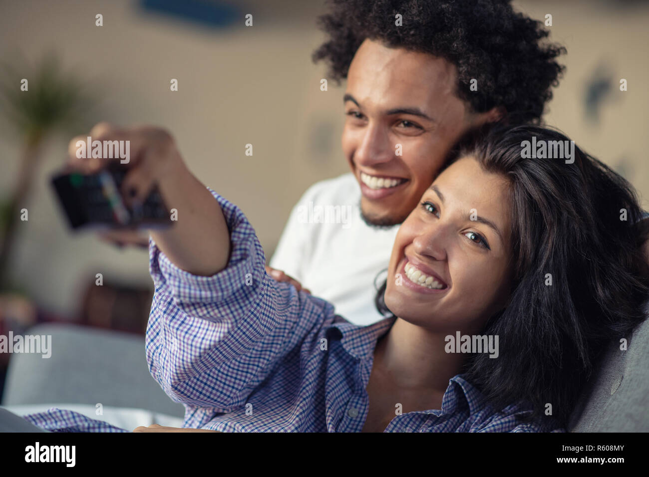 Young black couple relaxing on couch and smiling at camera Stock Photo ...