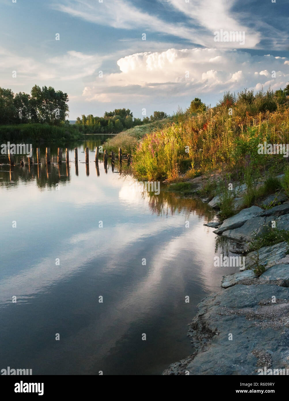 evening light and clouds are reflected in the lake in burgenland Stock Photo