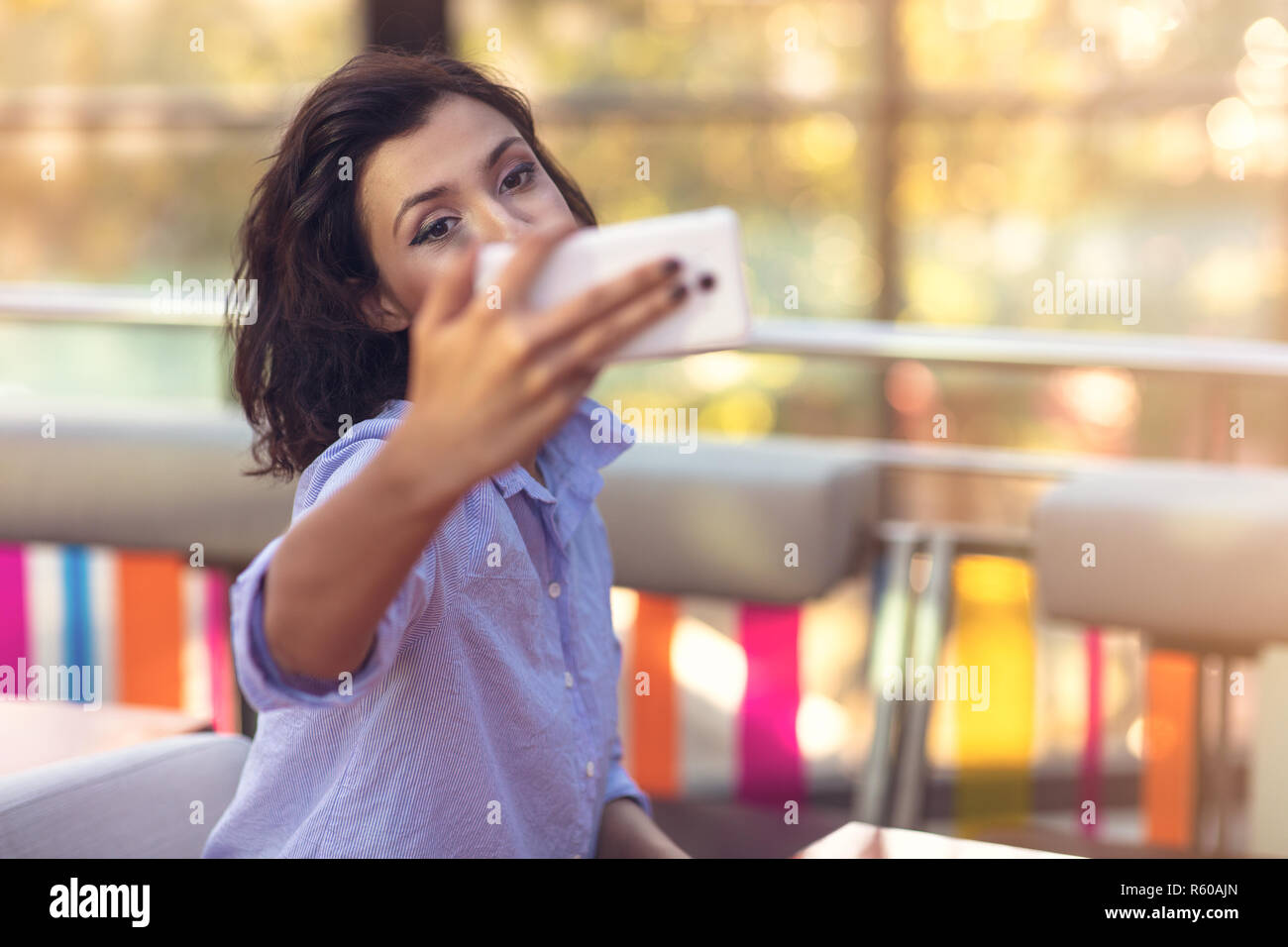 Young woman taking a selfie in coffee shop Stock Photo - Alamy