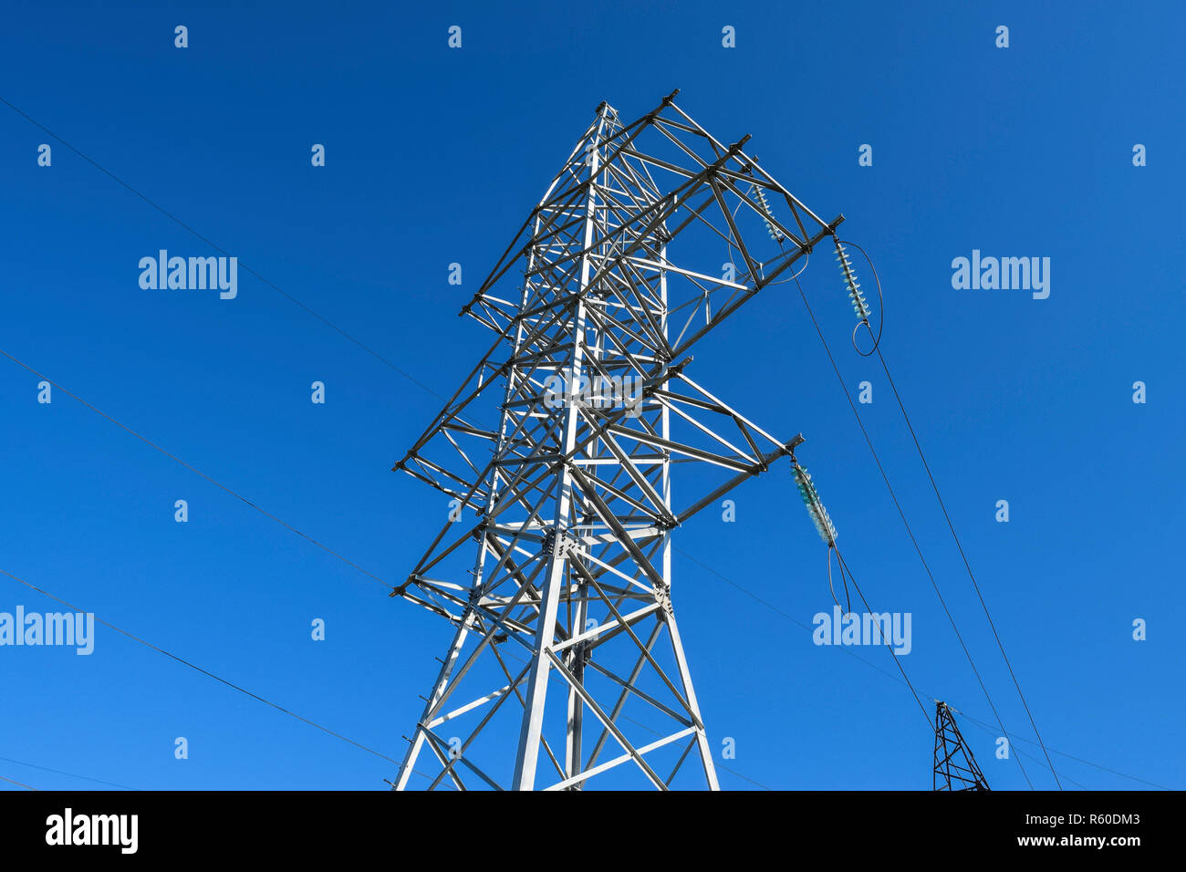 Supports high-voltage power lines against the blue sky Stock Photo - Alamy