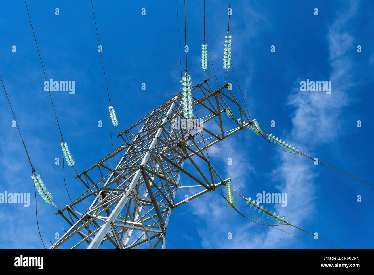 Supports high-voltage power lines against the blue sky with clou Stock ...