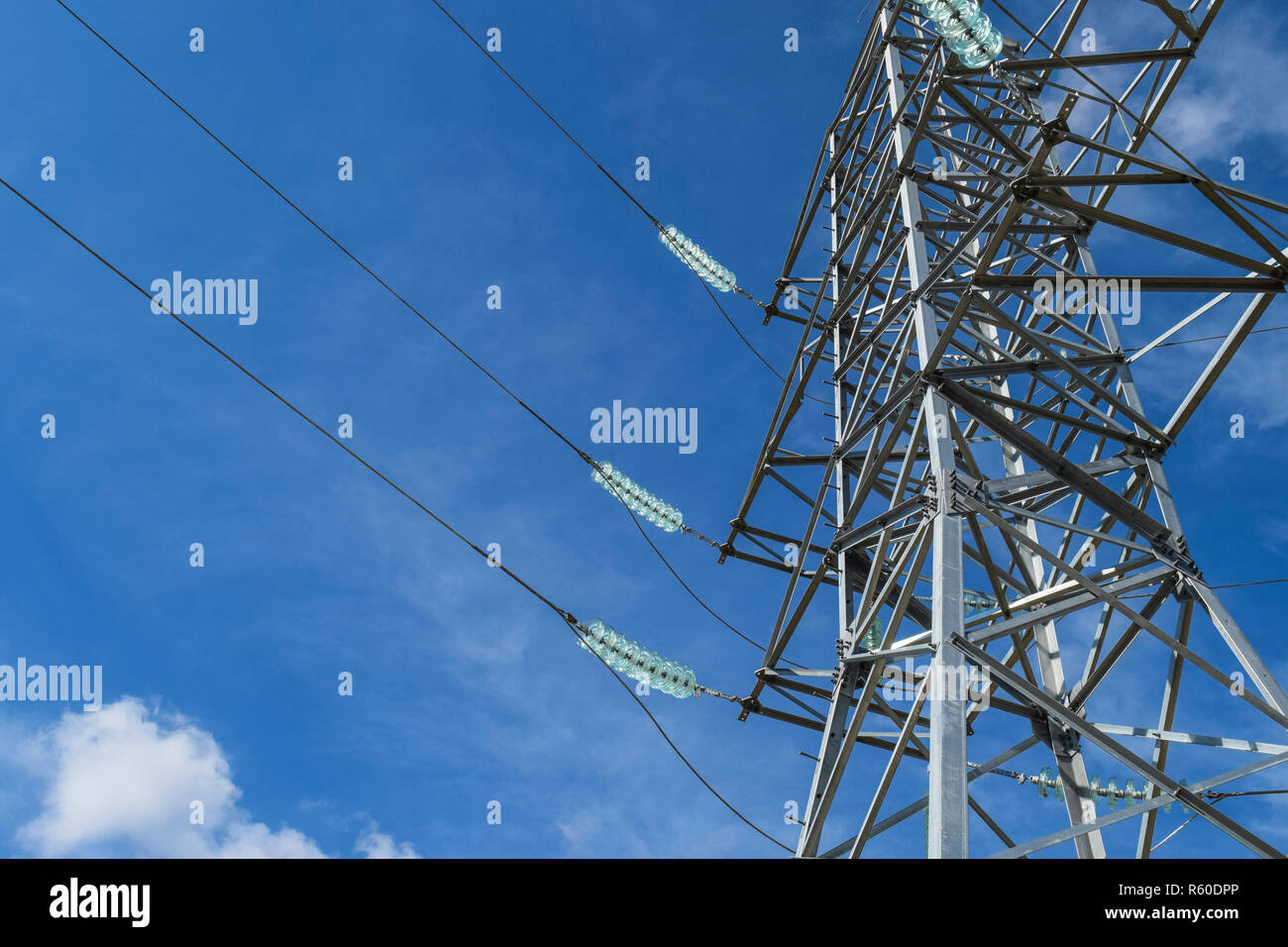 Supports high-voltage power lines against the blue sky with clou Stock ...