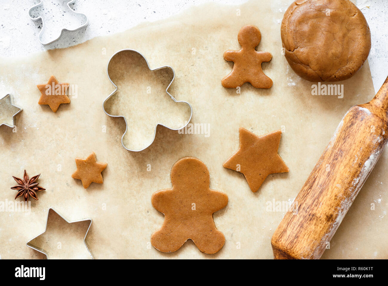 Gingerbread cookies on baking paper. Top view. Preparation of Christmas cookies. Holiday baking concept Stock Photo