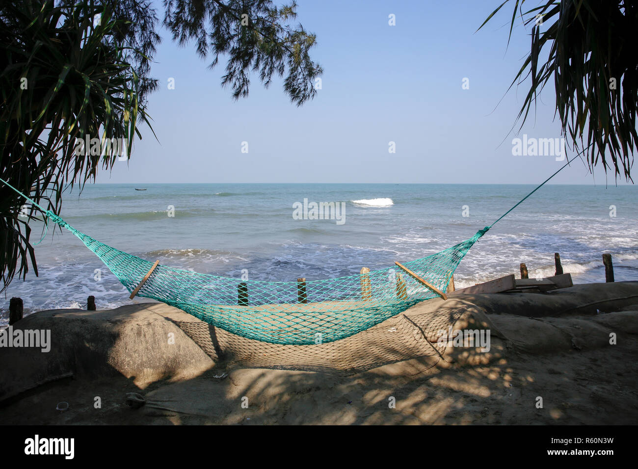 An empty hammock hangs beside a sea beach at Saint Martin Island. Cox’s Bazar, Bangladesh. Stock Photo