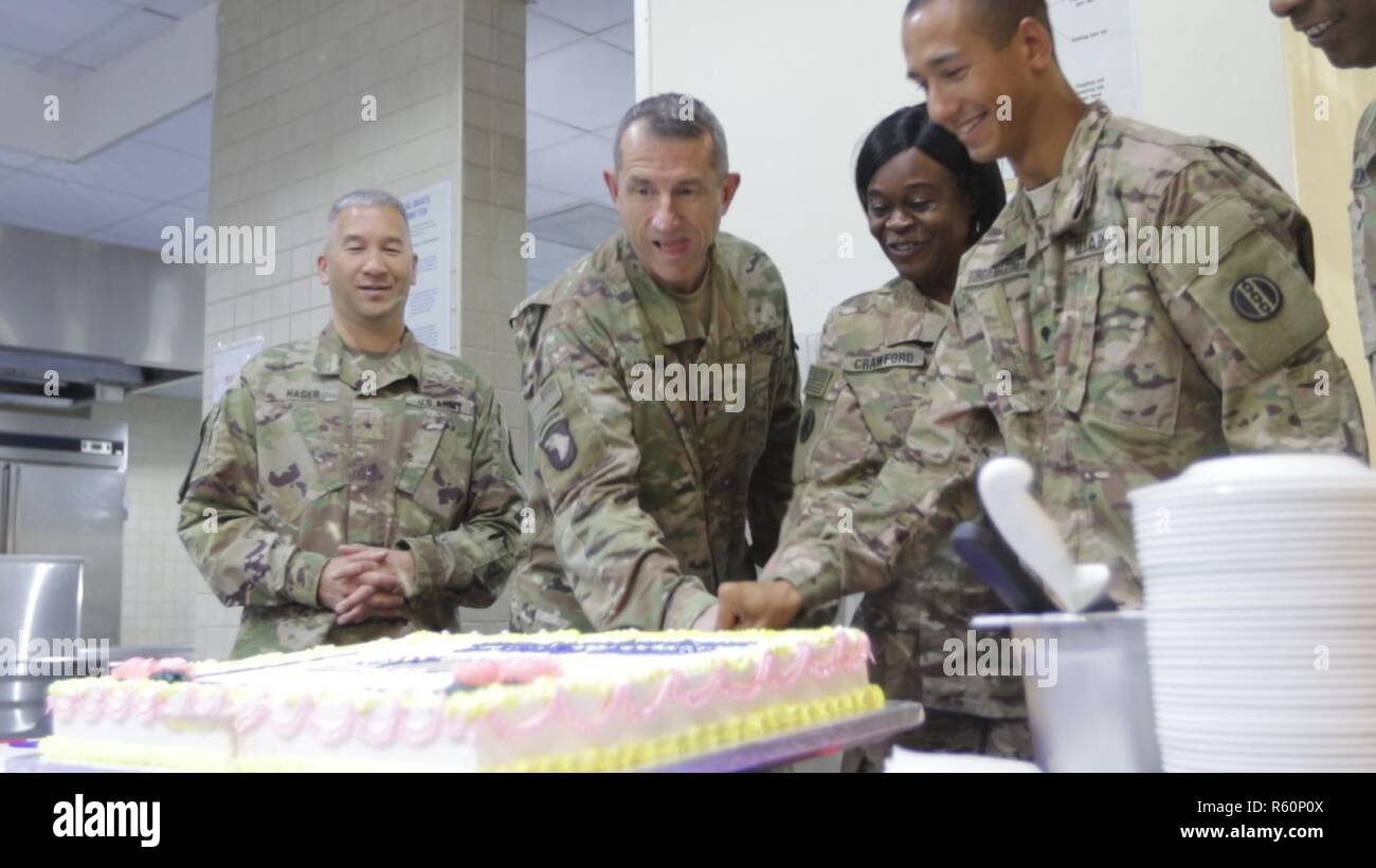U.S. Army Brig. Gen. Stephen Hager (left), commander of the 335th Signal Command, and U.S. Army Maj. Gen. William Hickman (2nd from left), deputy commanding general of U.S. Army Central, prepares to cut the cake with the elder U.S. Army Reserve Soldiers, Sgt. 1st Class Rosa Crawford (center), information technology specialist, 335th Signal Command, and youngest, Spc. Alberto BurgosMartinez (right), automated logistical specialist, 978th Quartermaster Company on April 22, at Camp Arifjan, Kuwait. The Army Reserve Engagement Cell hosted this annual event, as part of a celebratory day geared towa Stock Photo