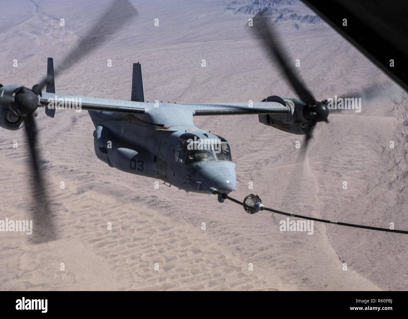 U.S. Marine Corps MV-22B Osprey refuels from a KC-130J Super Hercules during final exercise three (FINEX 3) as part of Weapons and Tactics Instructors Course (WTI) 2-17, near Chocolate Mountain Aerial Gunnery Range, Calif., April 29, 2017. FINEX 3 was designed to execute a simulated special operating forces raid while simultaneously supporting regimental combat team objectives and focusing on conducting all six functions of Marine Aviation. WTI is a seven-week training event hosted by Marine Aviation Weapons and Tactics Squadron one (MAWTS-1) cadre, which emphasizes operational integration of  Stock Photo