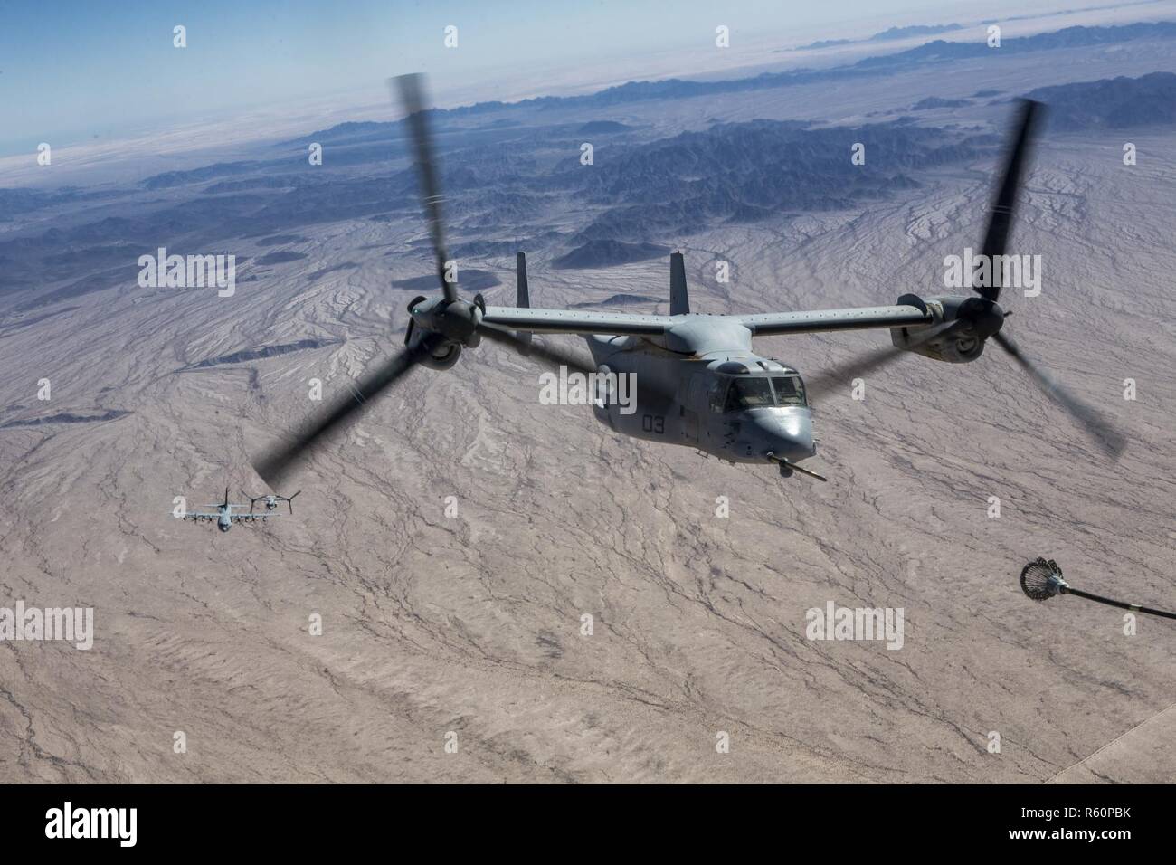 A U.S. Marine Corps MV-22B Osprey prepares to refuel from a KC-130J Super Hercules during final exercise three (FINEX 3) as part of Weapons and Tactics Instructors Course (WTI) 2-17, near Chocolate Mountain Aerial Gunnery Range, Calif., April 29, 2017. FINEX 3 was designed to execute a simulated special operating forces raid while simultaneously supporting regimental combat team objectives and focusing on conducting all six functions of Marine Aviation. WTI is a seven-week training event hosted by Marine Aviation Weapons and Tactics Squadron one (MAWTS-1) cadre, which emphasizes operational in Stock Photo