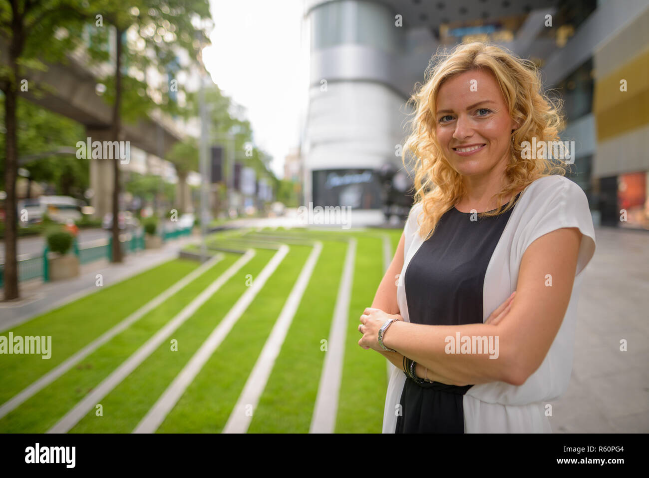 Portrait of beautiful blonde businesswoman smiling outdoors Stock Photo