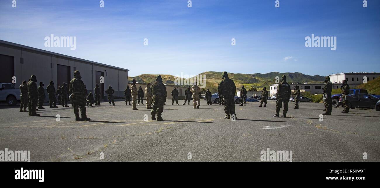 U.S. Marines from 1st Maintenance Battalion, 1st Marine Logistics Group, gather trainees to conduct Reconnaissance, Surveillance and Decontamination Training aboard Marine Corps Base Camp Pendleton, Calif., April 26, 2017. The trainees are receiving one final brief before separating into their training groups. The purpose of this training is to accomplish missions within a chemical, biological, radiological and nuclear environment. Stock Photo
