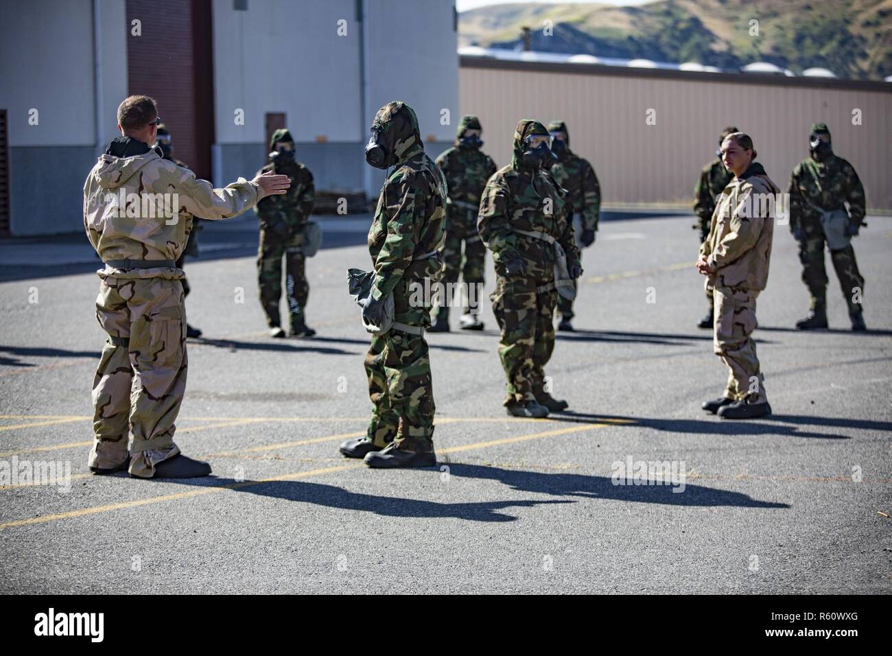 U.S. Marine Staff Sgt. Philip Barnes (left) instructs trainees in order to conduct the Reconnaissance, Surveillance and Decontamination Training aboard Marine Corps Base Camp Pendleton, Calif., April 26, 2017. Barnes goes over different safety precautions, prior to the trainees separating into their different training groups. The purpose of this training is to accomplish missions within a chemical, biological, radiological and nuclear environment.  Barnes is the current CBRN chief for 1st Maintenance Battalion, 1st Marine Logistics Group. Stock Photo