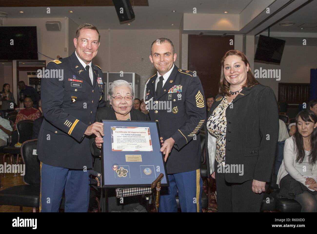 Yukie Furukawa, named Outstanding Volunteer of the Year, receives a plaque during Camp Zama's annual Volunteer Recognition Ceremony April 21 at the Camp Zama Community Club. Stock Photo