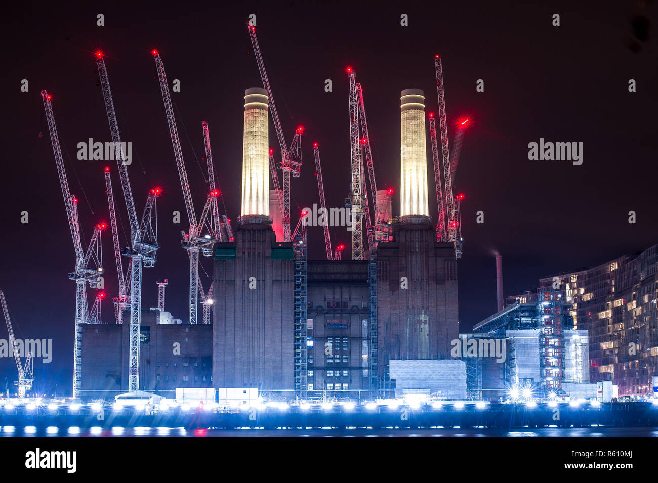 Cranes with their red warning lights illuminated surround Battersea