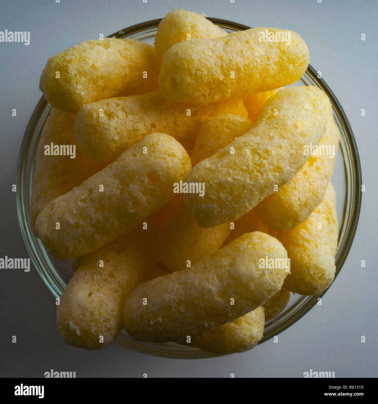 Corn Puffs in a Glass Bowl. Crunchy Flavored Puffed Snacks. Party
