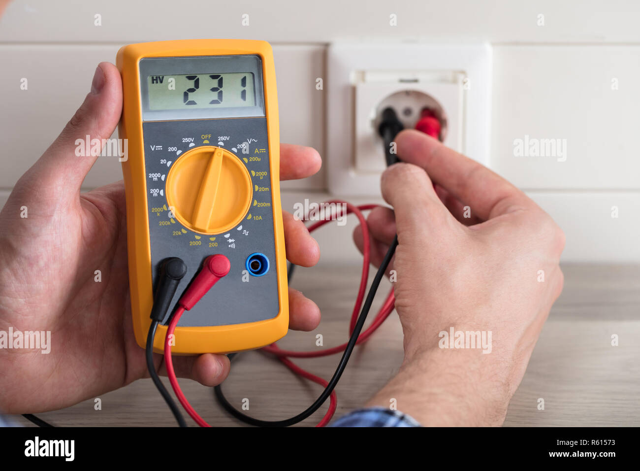 Male Electrician Checking Voltage Of Socket With Multimeter Stock Photo