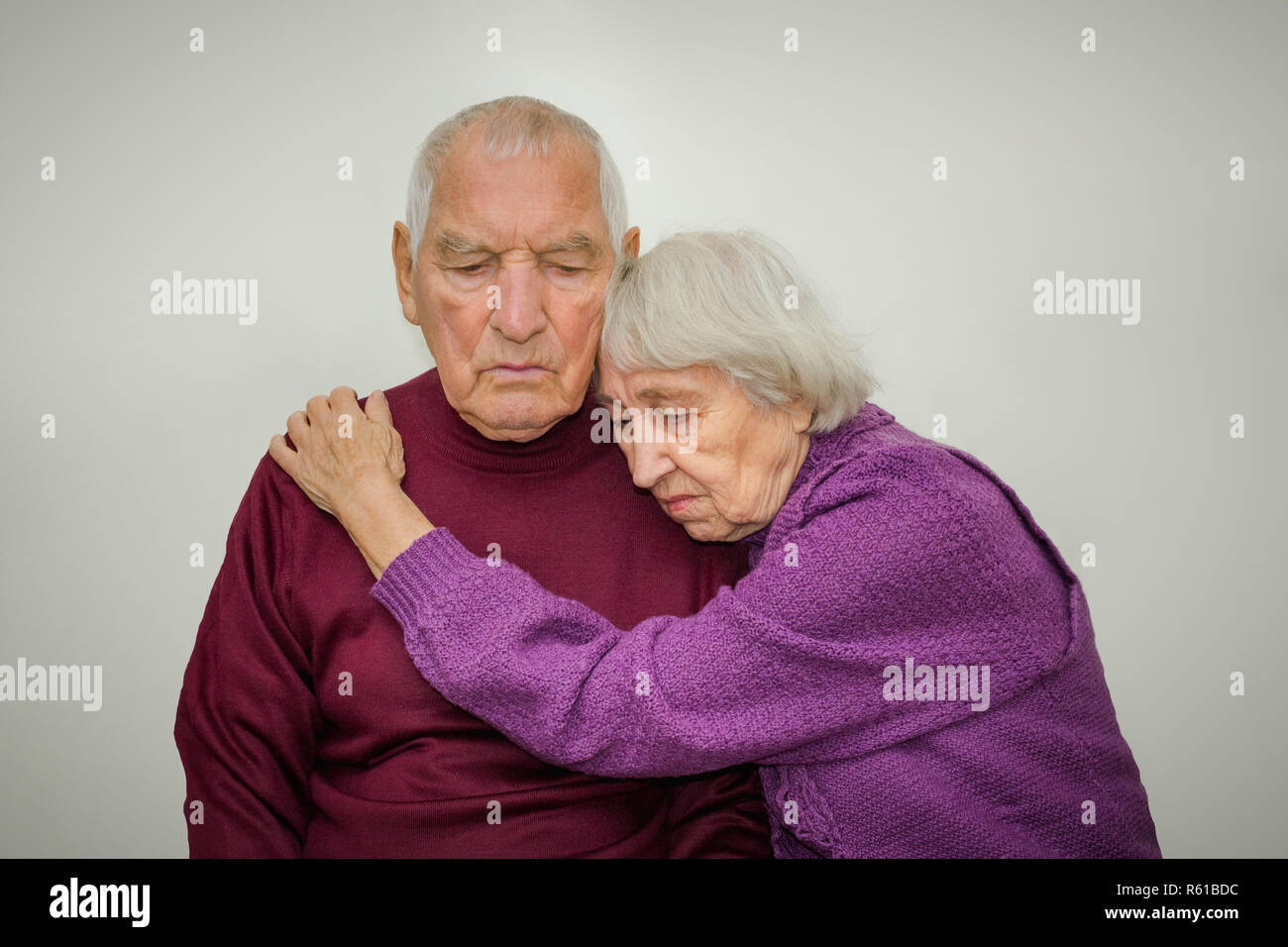 Sad elderly couple on a gray background Stock Photo