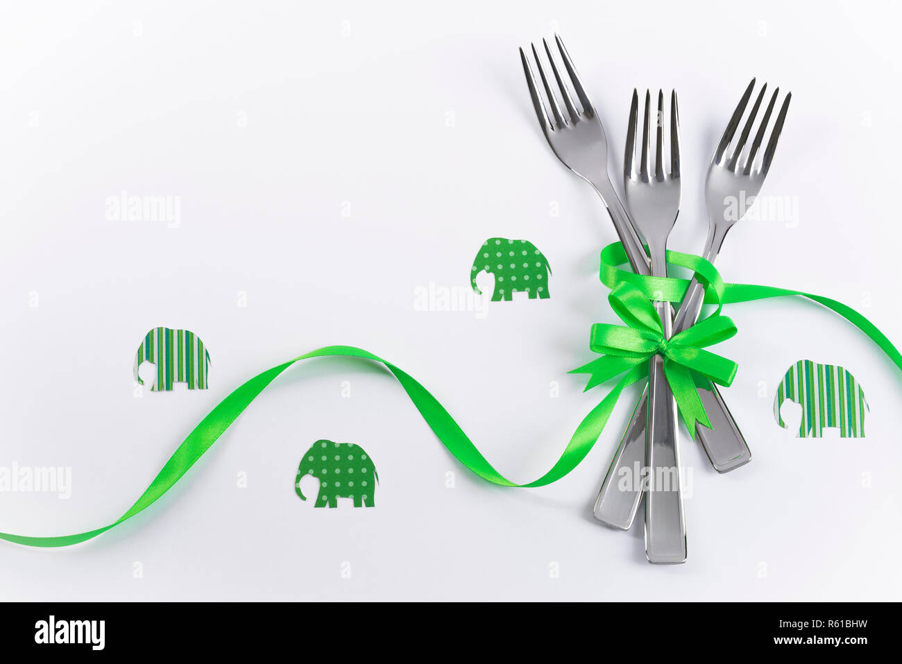 Silverware on white with green ribbon as background for menu and invitation Stock Photo
