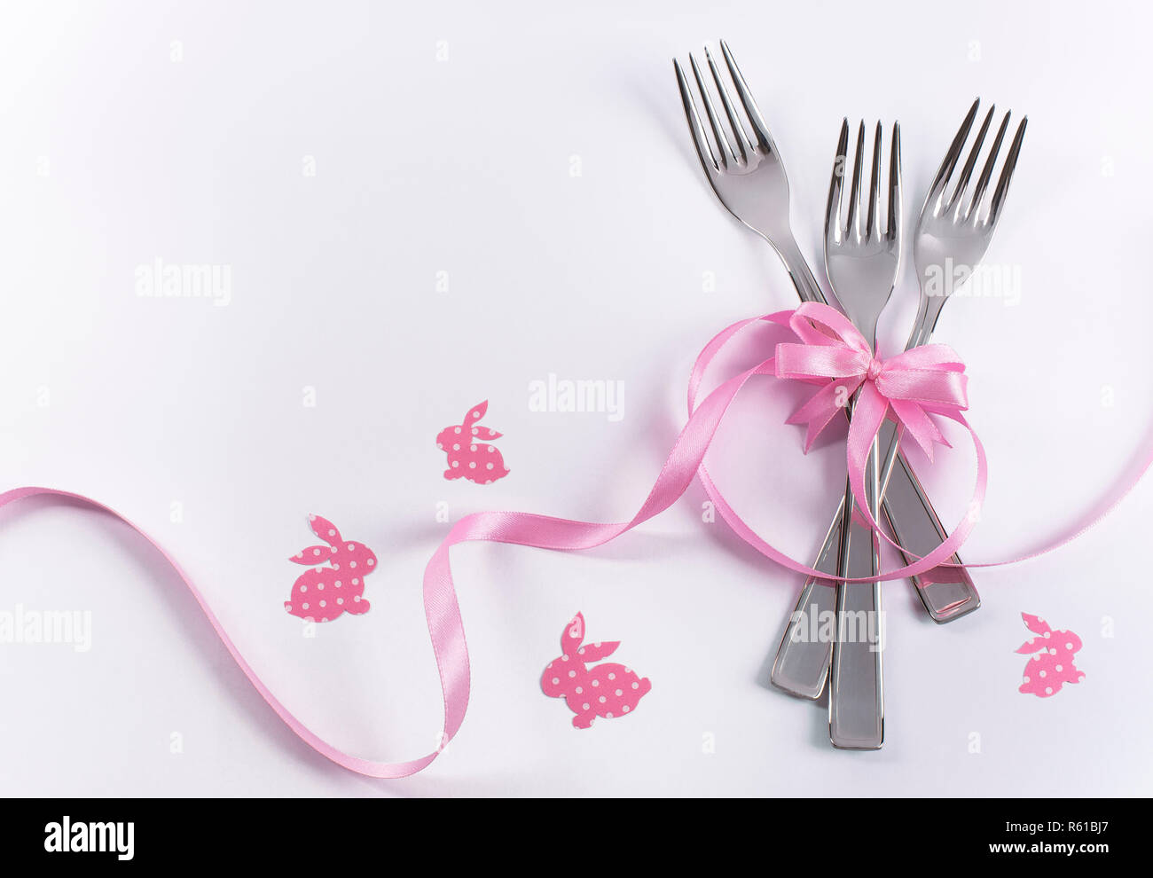 Silverware on white with pink ribbon as background for menu and invitation Stock Photo