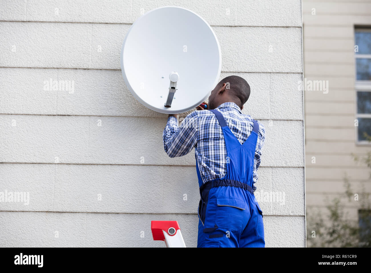 Man In Uniform Fitting TV Satellite Dish Stock Photo Alamy