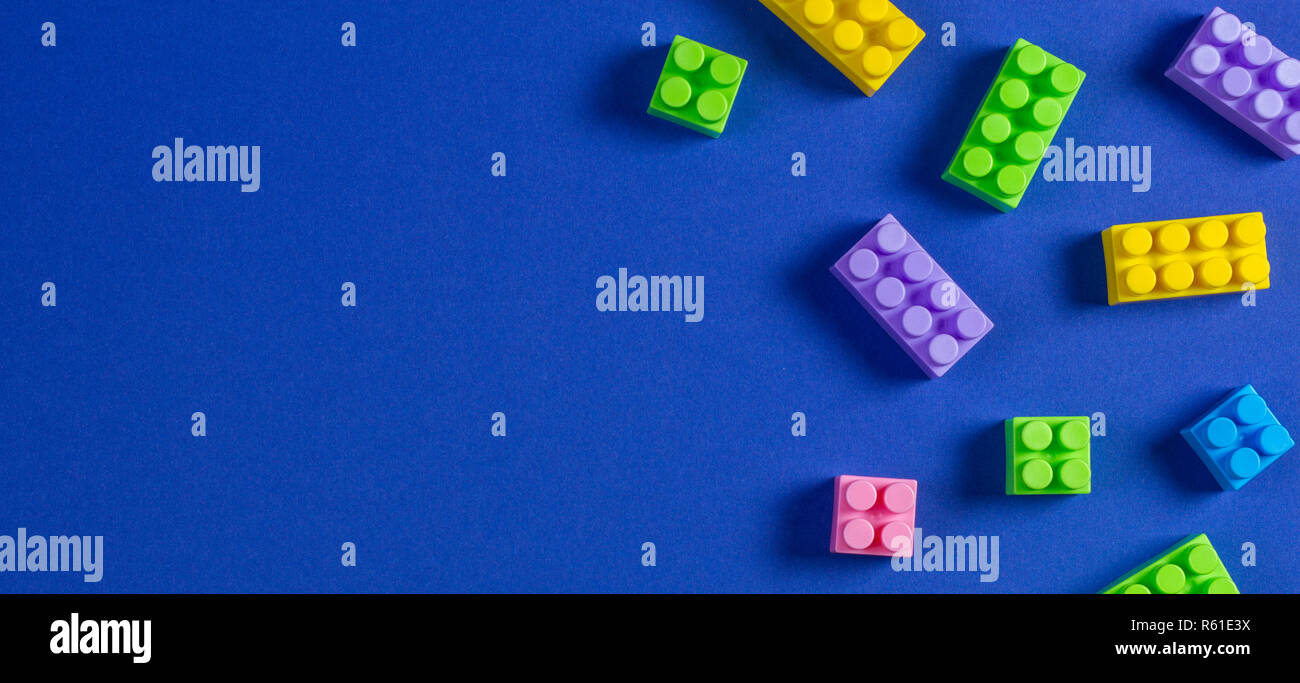Baby kid toys background. Colorful plastic construction blocks on blue ...