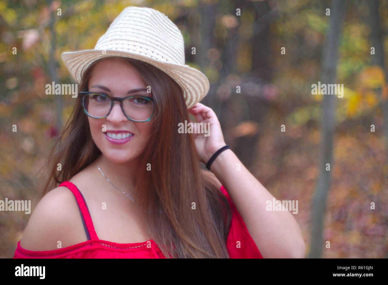 young woman hat glasses autumn red dress orange forest portrait Stock Photo