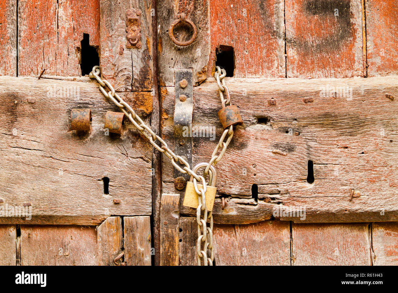 padlock with rusty chain on wooden door. locked gate. Stock Photo
