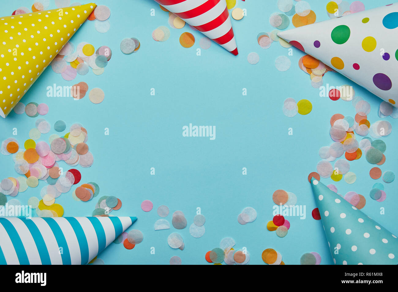Top view of party hats and confetti on blue background Stock Photo - Alamy