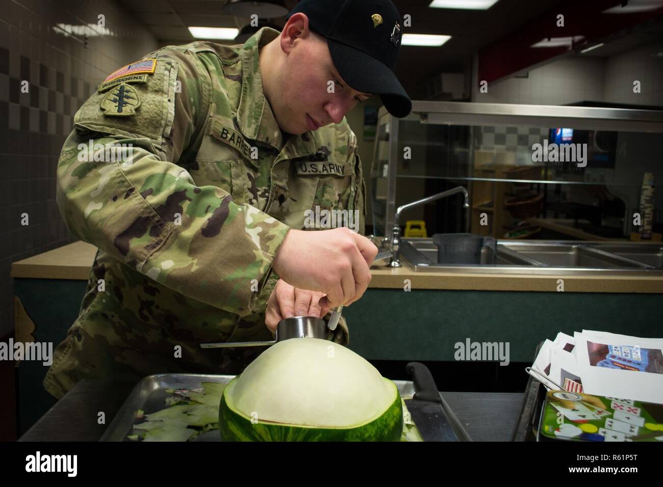Spc. Phil Barresi, a Culinary Specialist assigned to the 82nd Brigade Support Battalion, 3rd Brigade Combat Team, 82nd Airborne Division uses an Exacto-Knife to carve watermelon to be used as a garnish Monday, November 19, 2018 at the brigade’s dining facility.      Barresi and other Culinary Specialists from the battalion spent entire night preparing over 640 lbs. of turkey, 558 lbs. of steamship round, 72 lbs. of shrimp, more than 100 pies, approximately 700 servings of sweet potatoes and approximately 800 servings of green bean casserole to serve during the brigade’s Thanksgiving feast the  Stock Photo