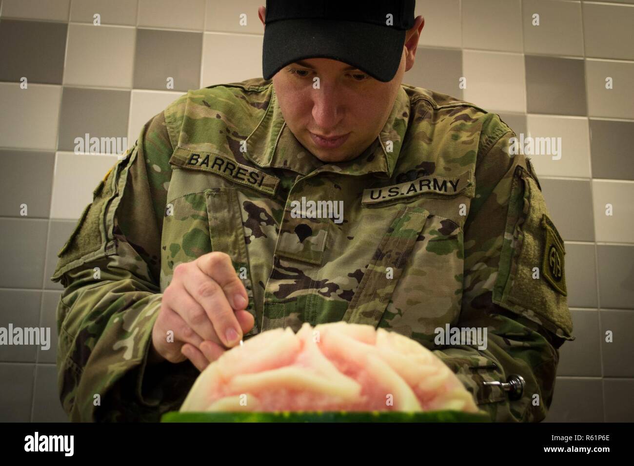Spc. Phil Barresi, a Culinary Specialist assigned to the 82nd Brigade Support Battalion, 3rd Brigade Combat Team, 82nd Airborne Division uses an Exacto-Knife to carve watermelon to be used as a garnish Monday, November 19, 2018 at the brigade’s dining facility.      Barresi and other Culinary Specialists from the battalion spent entire night preparing over 640 lbs. of turkey, 558 lbs. of steamship round, 72 lbs. of shrimp, more than 100 pies, approximately 700 servings of sweet potatoes and approximately 800 servings of green bean casserole to serve during the brigade’s Thanksgiving feast the  Stock Photo
