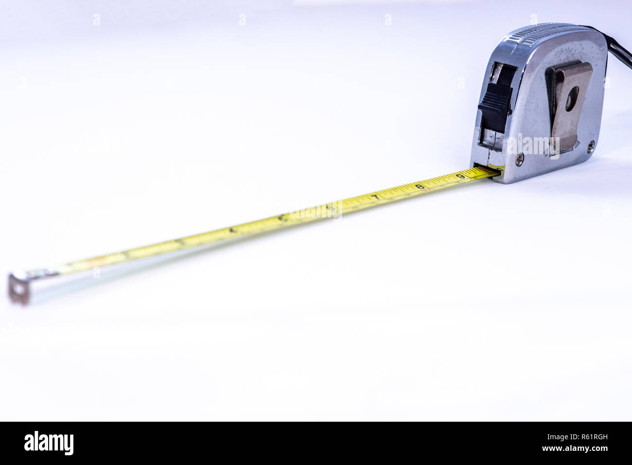 https://c8.alamy.com/comp/R61RGH/tape-measure-closeup-with-out-of-focus-elements-on-a-white-background-R61RGH.jpg