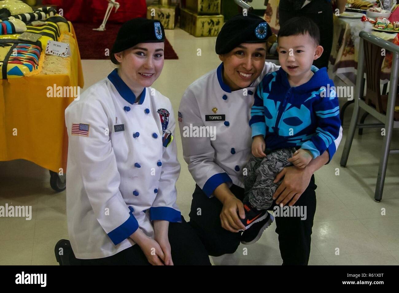 CAMP HUMPHREYS, Republic of Korea – Spc. Kayla Zapata, a native of Wickes Arkansas and Spc. Melissa Torres, a Houston native, both culinary specialist, 2nd Combat Aviation Brigade take a brief recess after setting up the Egyptian-themed design in Talon Café. They worked diligently for two days to create a unique atmosphere for Soldiers to enjoy during the Thanksgiving feast Nov. 22. Stock Photo