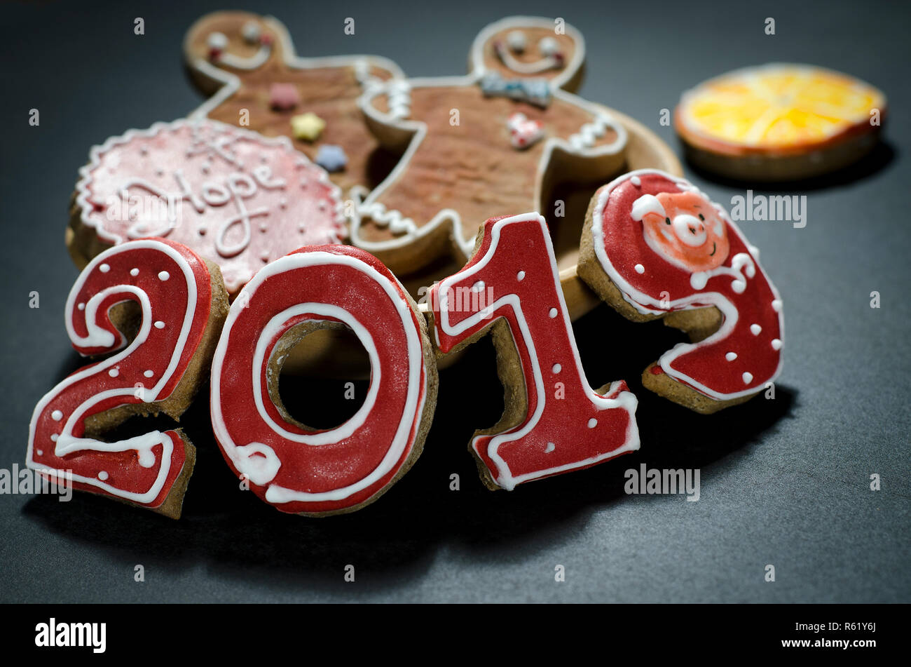 Christmas card on wood background gingerbread red numbers 2019 with slices of orange and gingerbread Mans Stock Photo