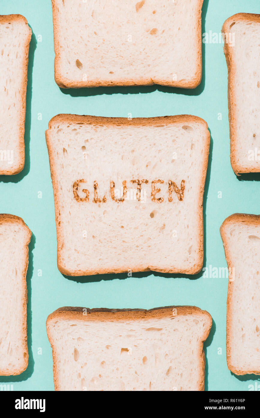 top view of bread slices with burned gluten sign on blue surface Stock