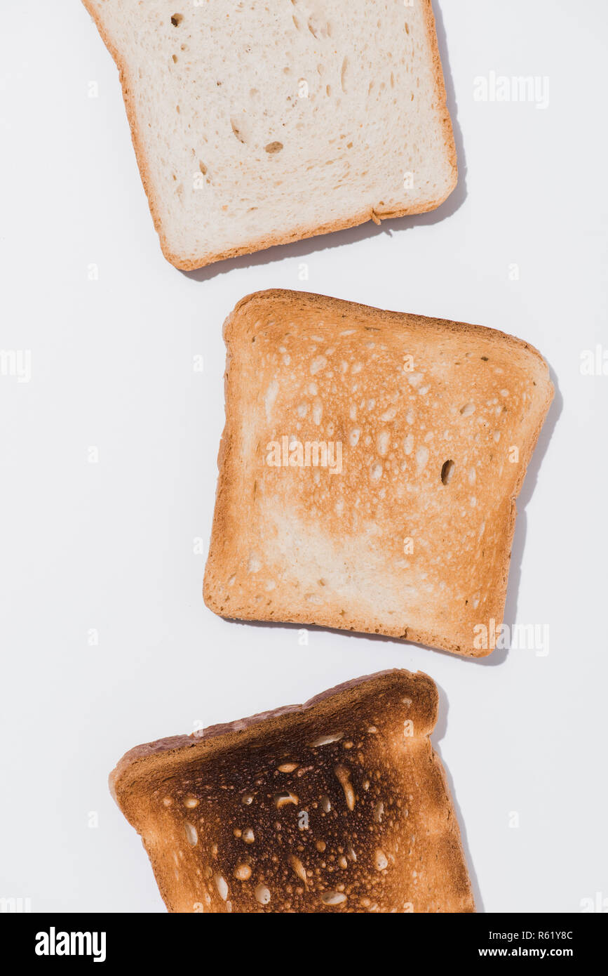 top view of toasts in various roast stages on white surface Stock Photo