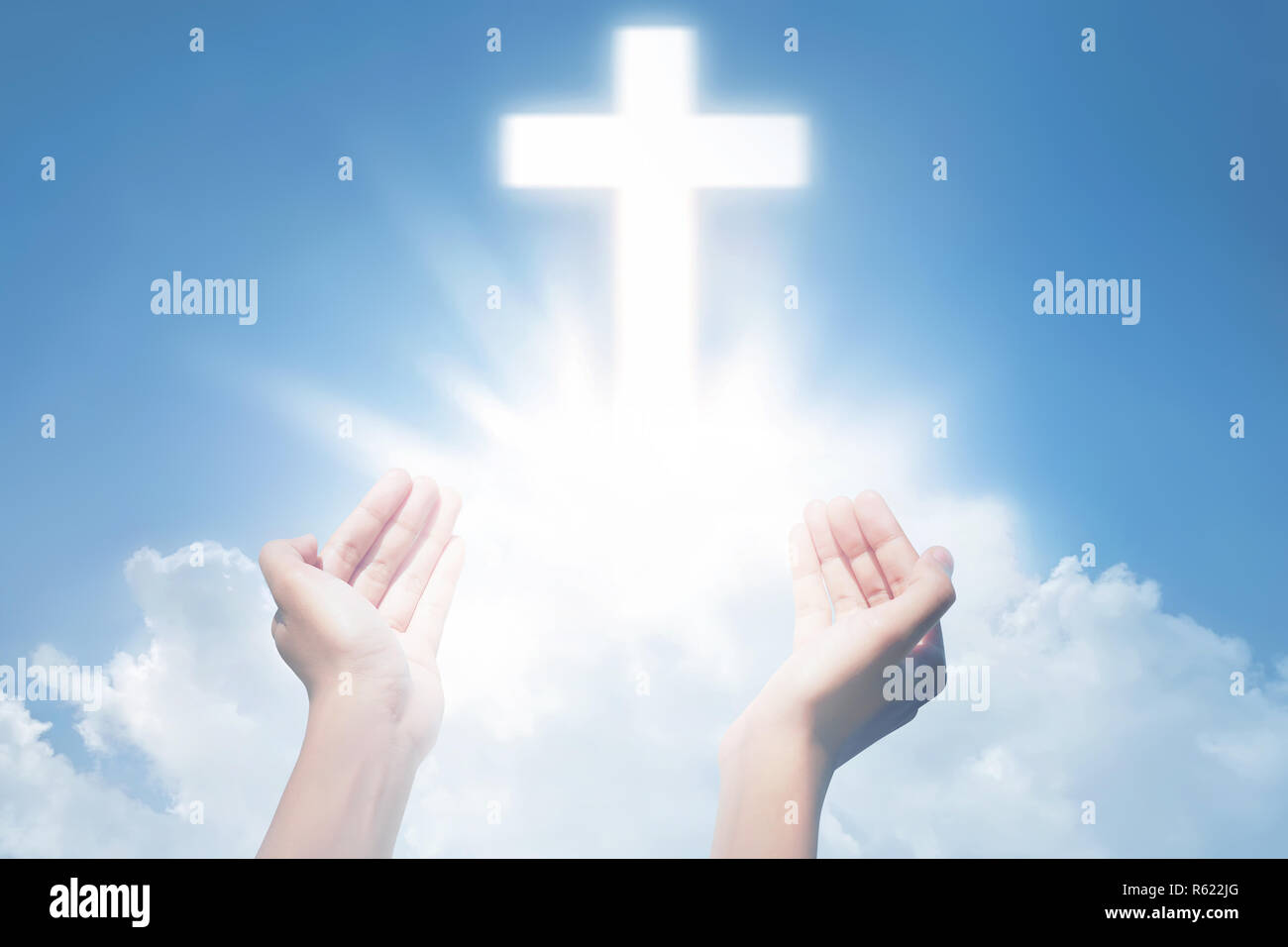 Human hands open palm and praying with cross Stock Photo