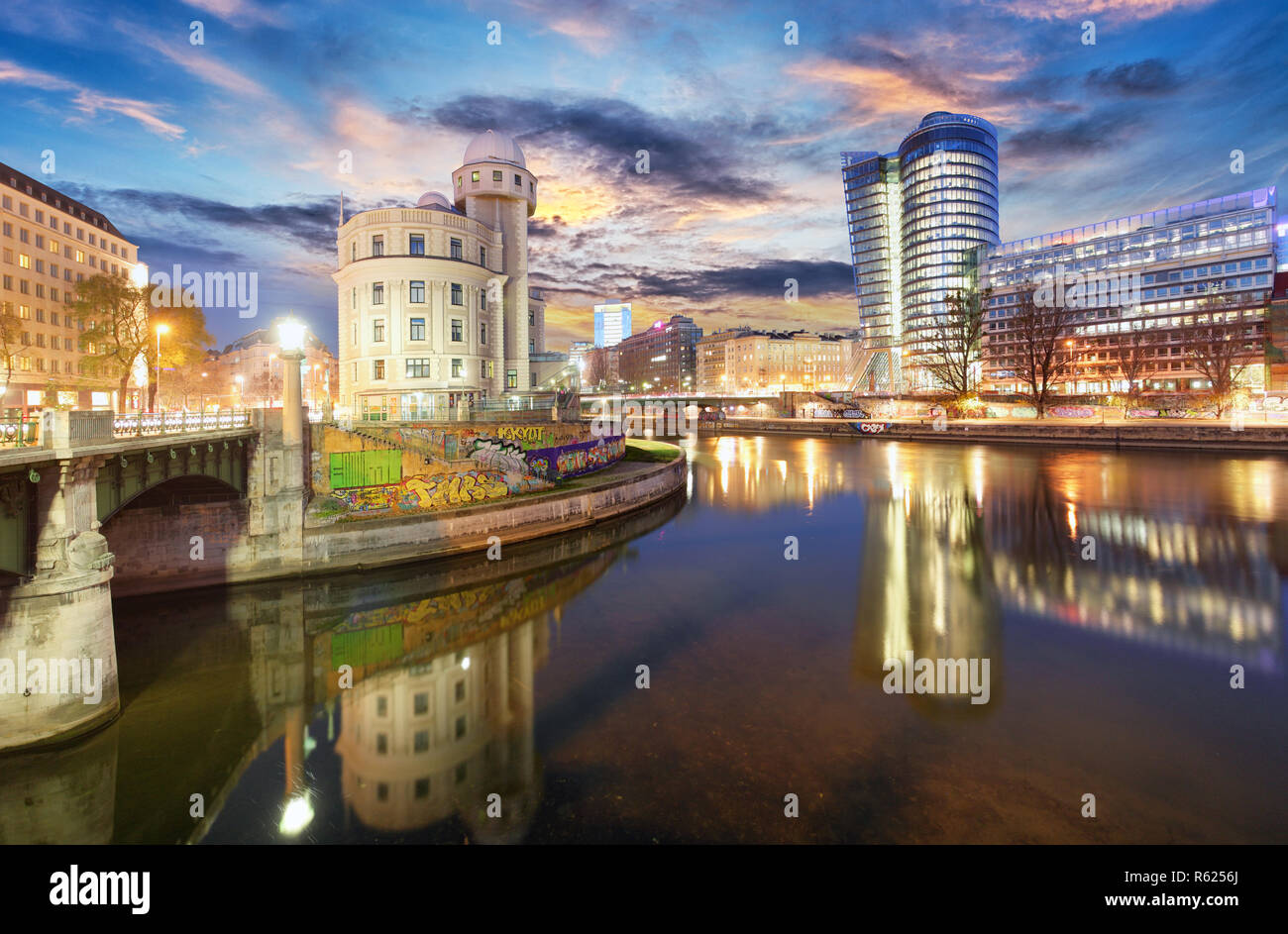 Danube Canal of Vienna, Austria. At the right the new UNIQA-Tower and opposite the historic building Urania. Stock Photo